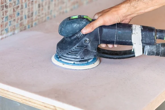 Hand schleift eine Oberfläche